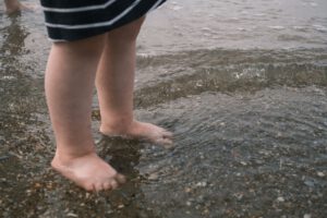 Kinderfüße im flachen Wasser