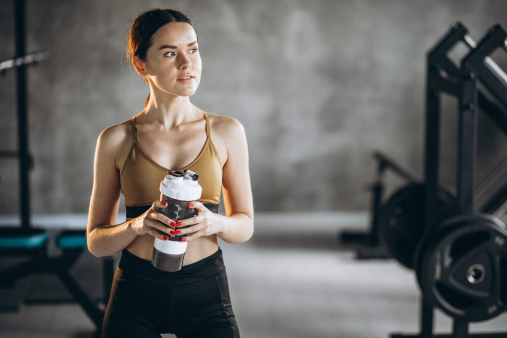 Frau trinkt im Gym