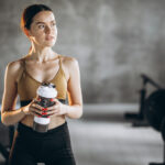 Frau trinkt im Gym