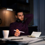 Mann arbeitet nachts am Laptop