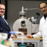 Zwei Forscher stehen im Labor vor einem Mikroskop.