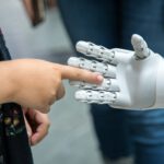 Mädchen berührt Roboterhand
