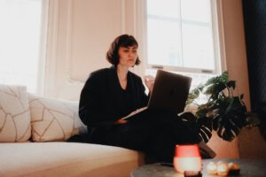 Auf dem Sofa am Laptop arbeiten: Nicht immer sieht Homeoffice so entspannt aus. Dennoch können Störungen zu Hause besser selbst gesteuert werden. Laut einer Studie steigt die Produktivität im Homeoffice auch deshalb, weil Unterbrechungen seltener den Arbeitsfluss stören. © Pexels