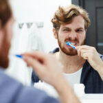 Mann putzt sich die Zähne