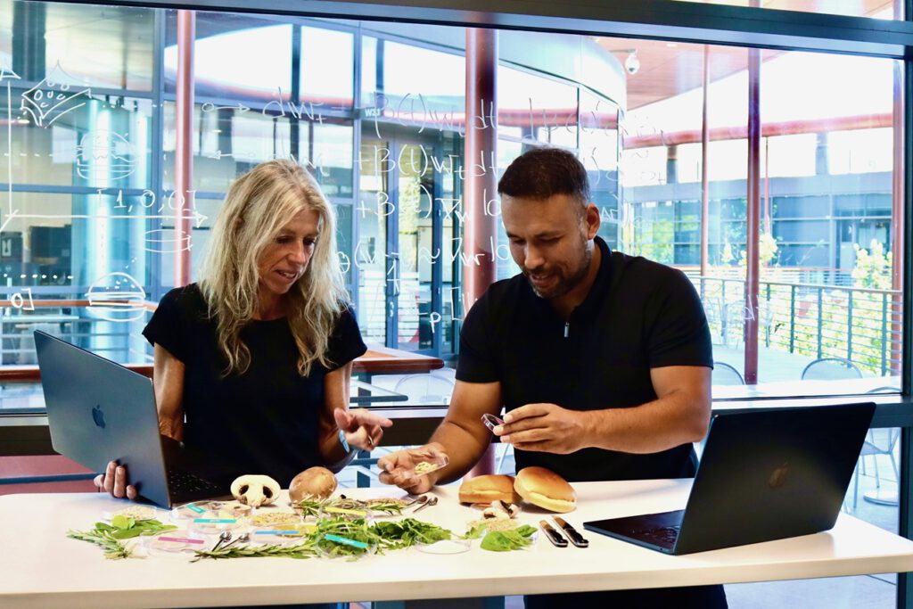 Ellen Kuhl und Vahidullah Tac testen Zutaten für BurgerAI: Aus Pilzen, Kräutern, Getreide und Daten soll ein Burger entstehen, der schmeckt – und zugleich Umweltbilanz und Nährwert verbessert.