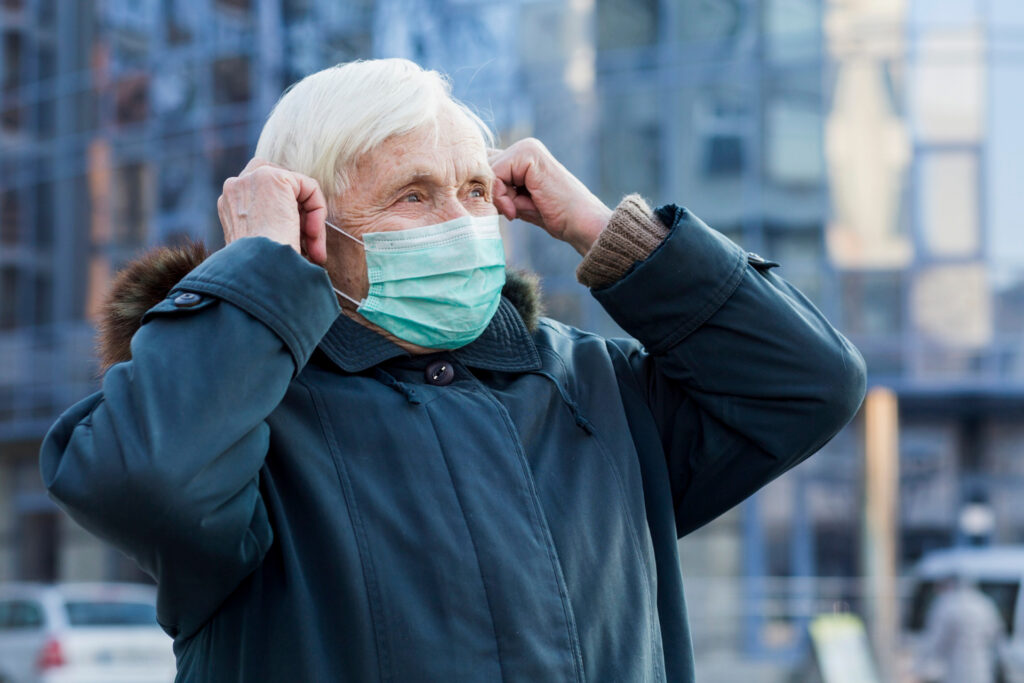Älterer Mann in der Stadt mit Maske