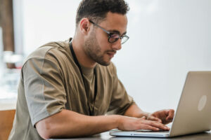 Junger Mann vor dem Laptop