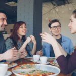 Gruppe junger Menschen unterhält sich im Restaurant
