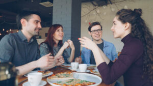Gruppe junger Menschen unterhält sich im Restaurant